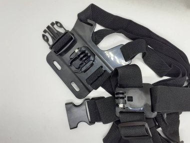 Beyaz izolasyon arka planında aksesuarları olan küçük siyah ve gri bir kamera.