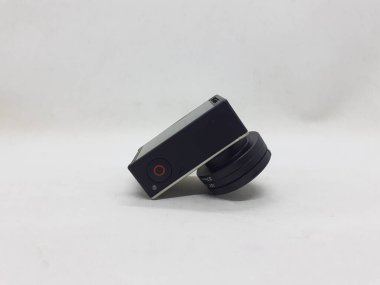 Beyaz izolasyon arka planında aksesuarları olan küçük siyah ve gri bir kamera.