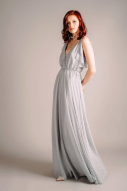 Toz mavisi elbiseli güzel bir kadın. Stüdyoda yüksek topuklu ayakkabılarla dans eden gecelikli kızıl kadının stüdyo portresi. Bekarlığa veda partisi için nedime kıyafeti.