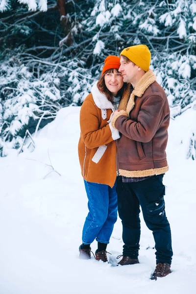 Pareja hombre y mujer abrazando en un fondo de bosque nevado — Foto de Stock