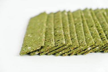 Beyaz arka planda yosunlu çıtır cipsler ve spirulina..