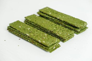 Beyaz arka planda yosunlu çıtır cipsler ve spirulina..