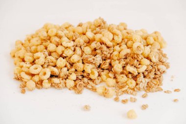 Beyaz arka planda kuru müsli, mısır gevreği, fındık ve kuru üzüm..