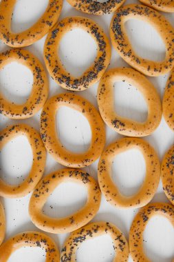 Beyaz arka planda haşhaş tohumlu kurutulmuş simit..