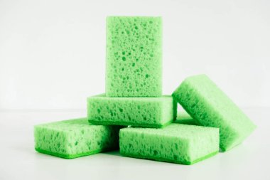 Beyaz arka planda temizlik için yeşil süngerler.