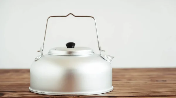 Металлический чайник для пеших прогулок на деревянном фоне стола — стоковое фото