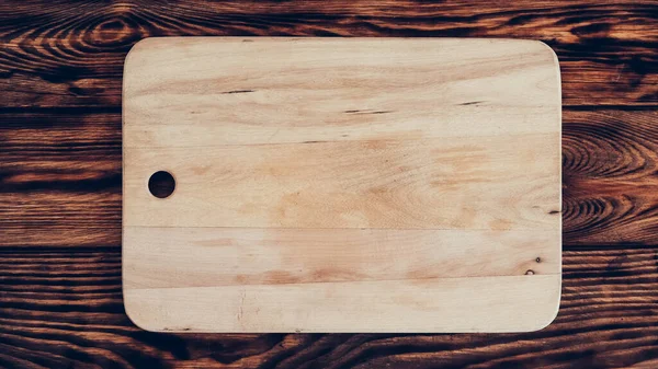茶色のテーブルの背景に木製のまな板 — ストック写真