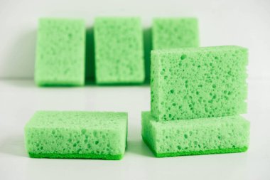 Beyaz arka planda temizlik için yeşil süngerler.