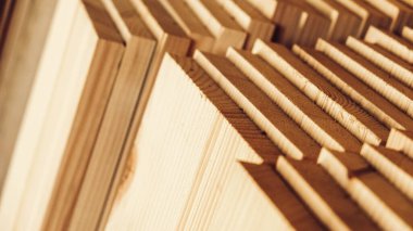Stacked wooden carpentry boards from natural wood in a woodworking industry.