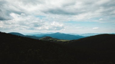 Ormanın ortasında Karpatların yeşil dağları dramatik bir gökyüzünün arka planına karşı.