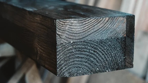 Wooden element of the carpentry beam is painted black.
