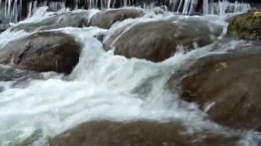 The stream flows through the rocks and rocks in the stream.