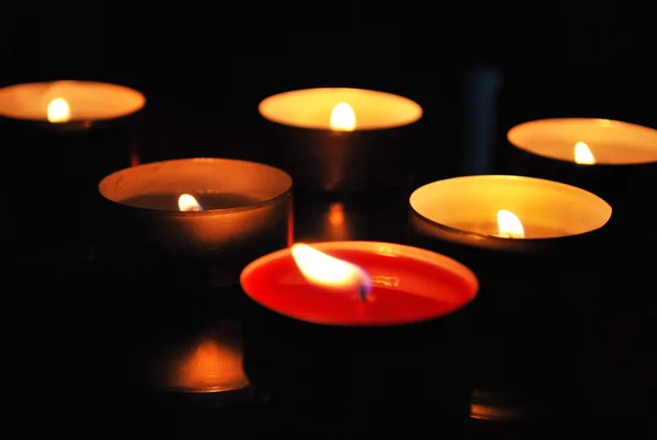 Karanlıkta yanan birçok küçük mumlar