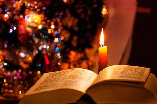 Santa Biblia con vela en bokeh — Foto de Stock