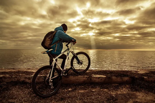 Een man met een fiets in de buurt van de zee Stockafbeelding