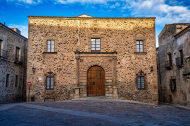 İspanya, Extremadura, Caceres 'deki Piskoposluk Sarayı. Santa Maria Meydanı 'nda, ana cephe, Rönesans tarzı, çift sıra küllerle süslenmiş yarım nokta kemerli dubası var.