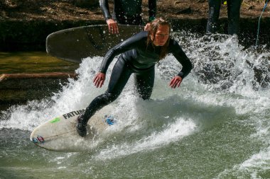 Münih, Almanya - 13 Temmuz 2021: Münih şehir nehrinde sörfçü, Eisbach adı verilen kentsel çevrede sörf yapan insanlarla ünlüdür.