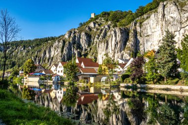 Markt Essing 'in yansımaları ve Almanya' nın Bavyera kentindeki Altmuehl nehri üzerindeki Randeck şatosunun harabesi ile günbatımı manzarası.