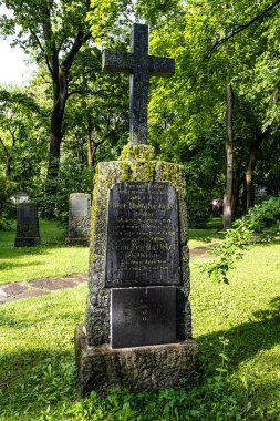Münih, Almanya - Temmuz 09, 2021: Tarihi mezar taşlarıyla ünlü Münih Eski Kuzey Mezarlığı manzarası. Cenazeler 1944 'ten beri burada yapılmadı. Bunun yerine mezarlık bir park olarak kullanılıyor.