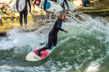 Münih, Almanya - 13 Temmuz 2021: Münih şehir nehrinde sörfçü, Eisbach adı verilen kentsel çevrede sörf yapan insanlarla ünlüdür.