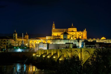 Cordoba, İspanya - 31 Ekim 2021: Mezquita-Katedral ve Puente Romano - Cami-Katedral ve gece İspanya 'nın Endülüs kentindeki Roma Köprüsü