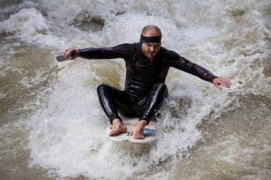 Münih, Almanya - Haziran 04, 2022: Şehir Nehrinde Sörfçü, Münih 'te Eisbach adı verilen kentsel çevrede sörf yapan insanlarla ünlüdür.