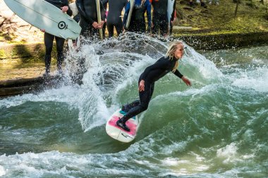 Münih, Almanya - Haziran 04, 2022: Şehir Nehrinde Sörfçü, Münih 'te Eisbach adı verilen kentsel çevrede sörf yapan insanlarla ünlüdür.