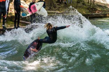 Münih, Almanya - Haziran 04, 2022: Şehir Nehrinde Sörfçü, Münih 'te Eisbach adı verilen kentsel çevrede sörf yapan insanlarla ünlüdür.
