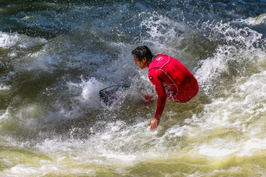 Münih, Almanya - Haziran 04, 2022: Şehir Nehrinde Sörfçü, Münih 'te Eisbach adı verilen kentsel çevrede sörf yapan insanlarla ünlüdür.