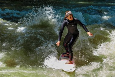 Münih, Almanya - Haziran 04, 2022: Şehir Nehrinde Sörfçü, Münih 'te Eisbach adı verilen kentsel çevrede sörf yapan insanlarla ünlüdür.