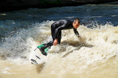 Münih, Almanya - Haziran 04, 2022: Şehir Nehrinde Sörfçü, Münih 'te Eisbach adı verilen kentsel çevrede sörf yapan insanlarla ünlüdür.