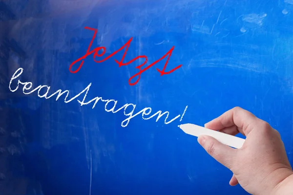 Person writing on chalk board — Stock Photo, Image