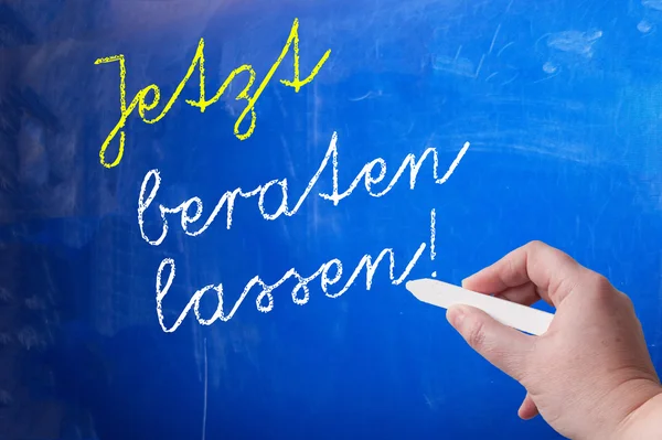 Person writing on chalk board — Stock Photo, Image