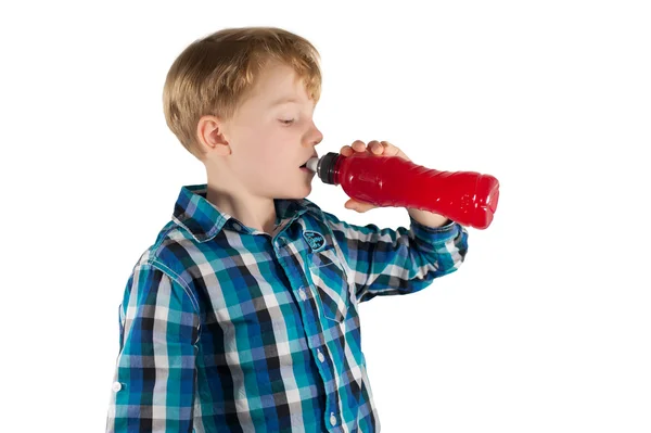 Retrato del niño bebiendo bebida isotónica sobre un fondo blanco —  Fotos de Stock