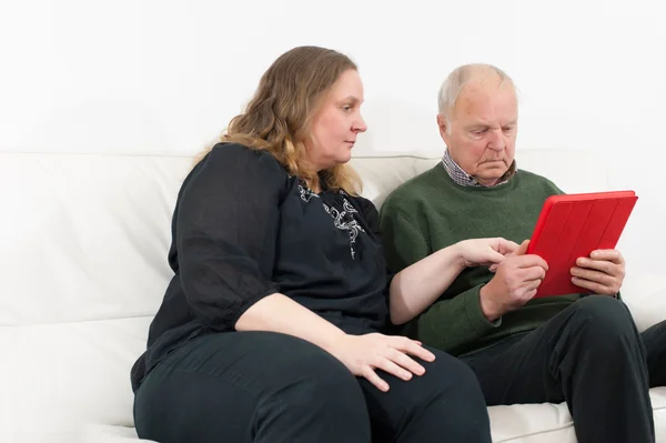 Junge Frau und Rentner am Tablet-PC — Stockfoto