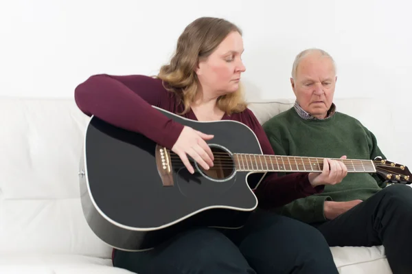 Gitar ve emekliler ile genç kadın — Stok fotoğraf