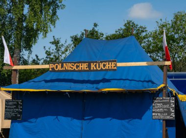 Market, Polonya mutfağını bir ortaçağ piyasa gösterisinde oyalıyor. Metindeki Almanca kelime: Polonya mutfağı.