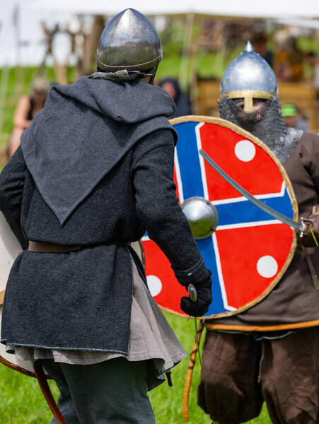 Show fight of medieval knights on a battlefield at the medieval market spectacle 
