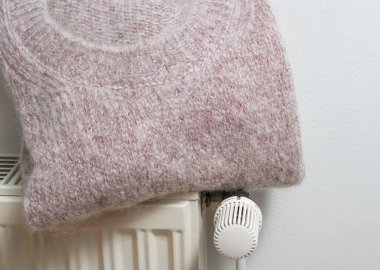 Soğuk kış mevsimi için ısıtıcının üstünde yün kazak.