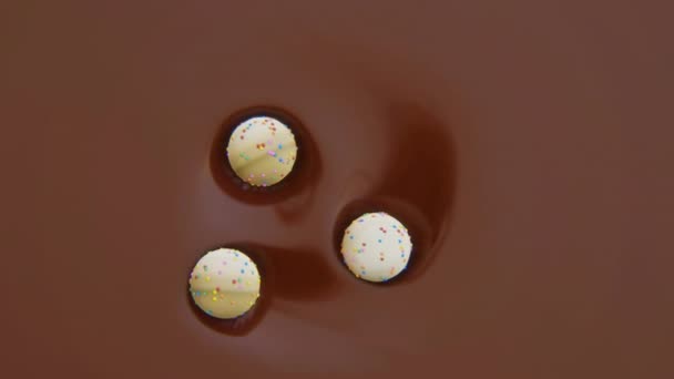 4k vídeo de tres dulces en movimiento en chocolate. — Vídeo de stock