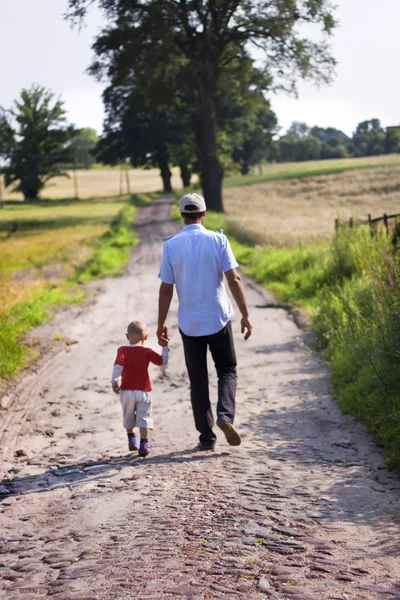 Baba ve oğul Köyü yolda yürürken Telifsiz Stok Imajlar