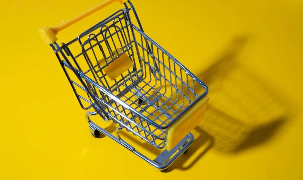 Egy Bevásárlókocsi Sárga Alapon Látható Szupermarketből Kis Kosár Elvont Háttér — Stock Fotó