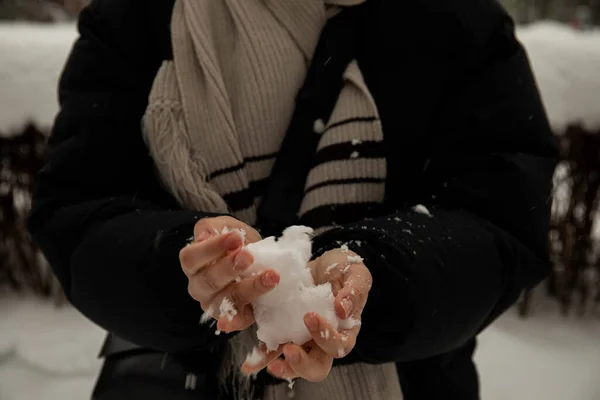 Девушка Черной Куртке Сером Шарфе Держит Снежок Руках Сжимает Бросает — стоковое фото