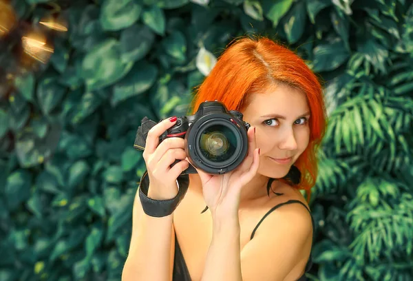 Profesyonel kameralı pankart. Fotoğrafçı. Arka planda yeşil bir duvar var. Boşluğu kopyala