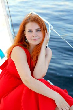 Yaz manzaralı bayrak. Ufuk, mavi nehir, kırmızı elbiseli genç kadın rüya gibi.