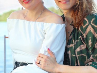 Doğada yan yana oturan iki genç kız arkadaş. Yaz. Arkadaşlık kavramı.