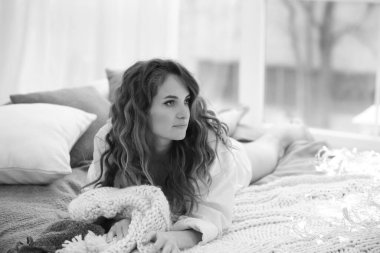 Siyah beyaz portresi olan pankart beyaz gömlekli genç bir kızın yatağında yatıyor. Dinlen. Rahat bir ortam. Rahat ol. Boşluğu sağda kopyala