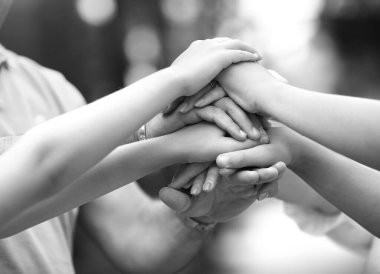 Siyah beyaz fotoğraf takım oluşturma konsepti. Ekibin ellerini doğanın arka planına yakın çekimde, bokeh etkisi ile.