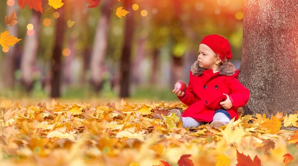 Szczęśliwa Biała Dziewczynka Czerwonym Płaszczu Berecie Parku Czerwonym Jabłkiem Siedzącym — Zdjęcie stockowe