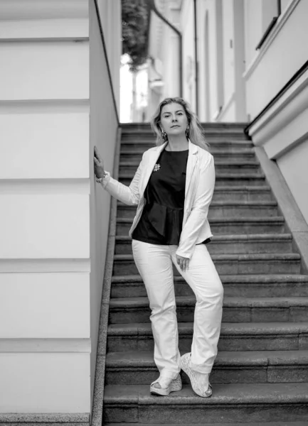 Черно Белый Портрет Женщины Белом Костюме Стоящей Лестнице Смотрящей Камеру — стоковое фото